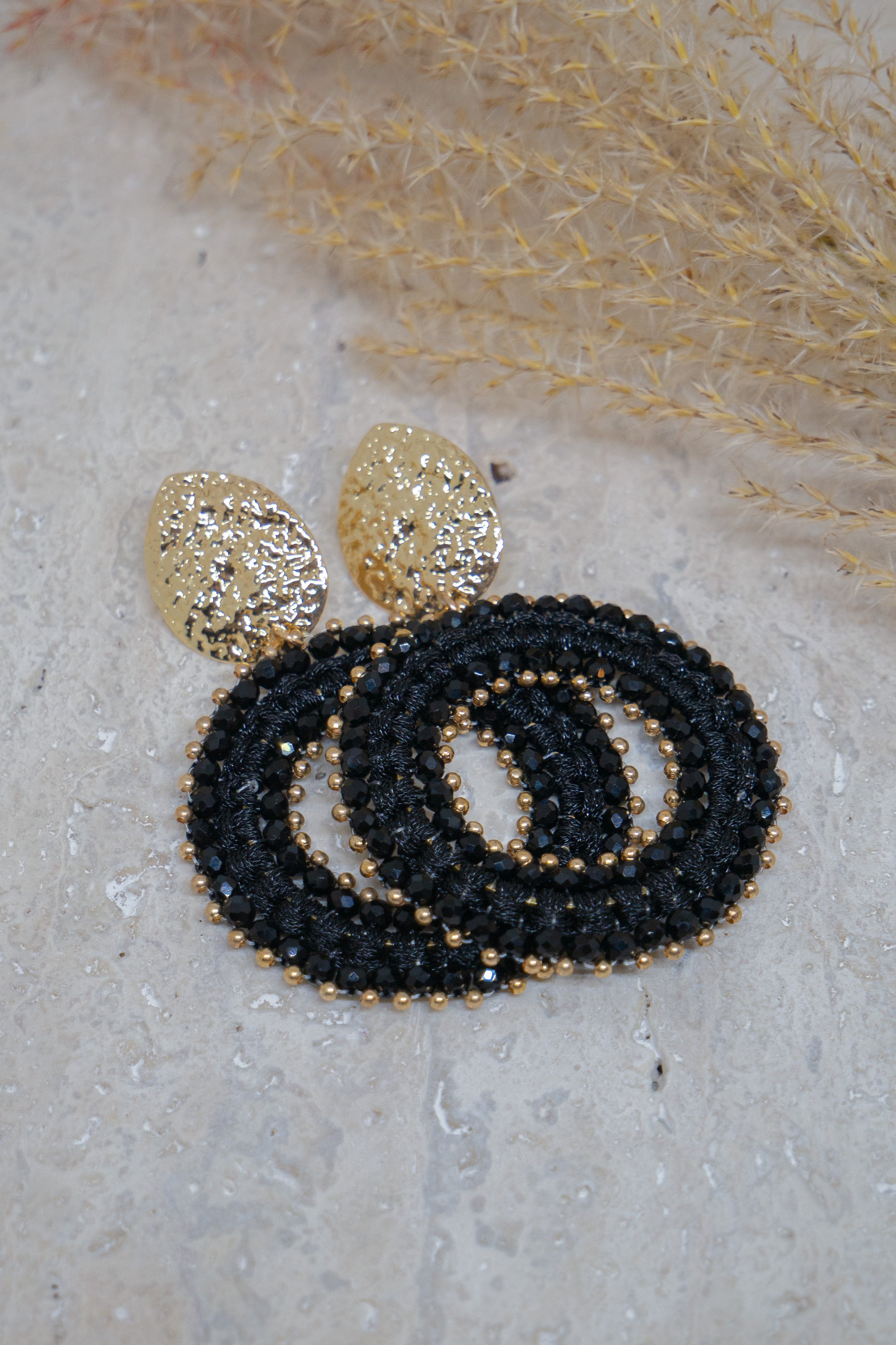 Zwarte statement oorbellen met gouden details 